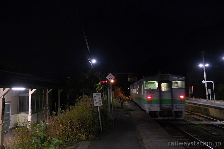 函館本線、夜の石谷駅を発車するキハ40の普通列車