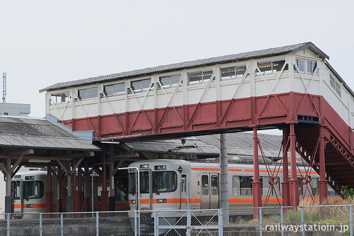 武豊線・半田駅、明治築の最古の跨線橋の下で列車交換する313系電車