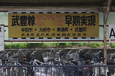 亀崎駅の自転車置場、武豊線の複線電化・高架を求める看板