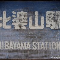 比婆山駅、古い駅時刻表を使いまわした駅名看板(大)
