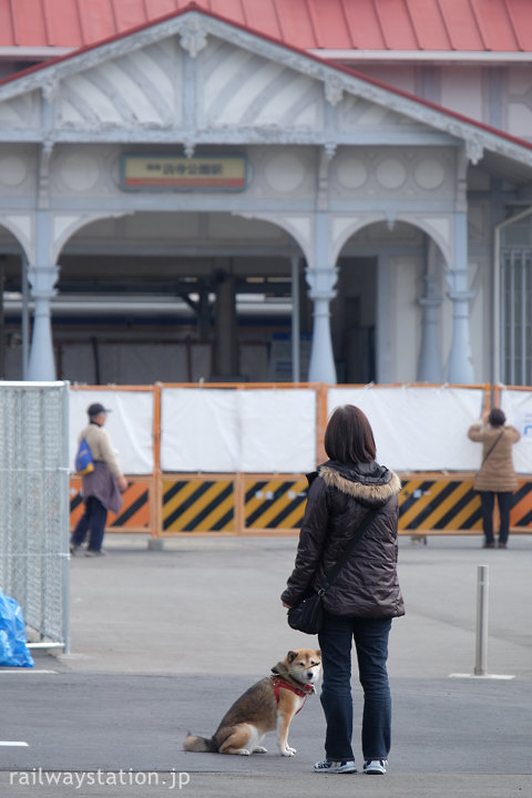 閉鎖された浜寺公園駅旧駅舎を見る犬の散歩中の人とわんこ